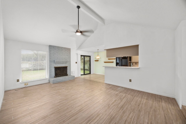 814 Pickford Dr, Katy, TX 77450 - unfurnished living room with ceiling fan, a fireplace, beam ceiling, light wood finished floors, and high vaulted ceiling