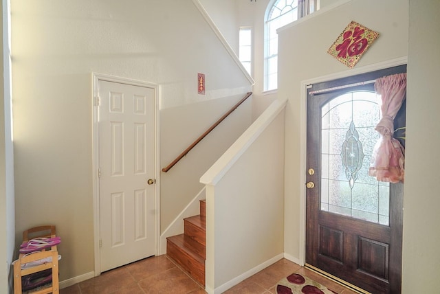 tiled entrance foyer with stairway and baseboards