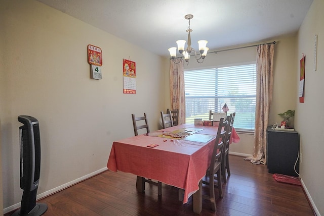 dining space featuring baseboards, wood finished floors, and a chandelier