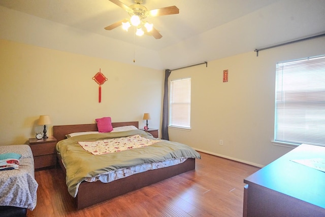 bedroom featuring baseboards, wood finished floors, and a ceiling fan