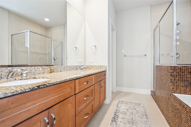 full bath with a stall shower, tile patterned floors, a sink, and double vanity