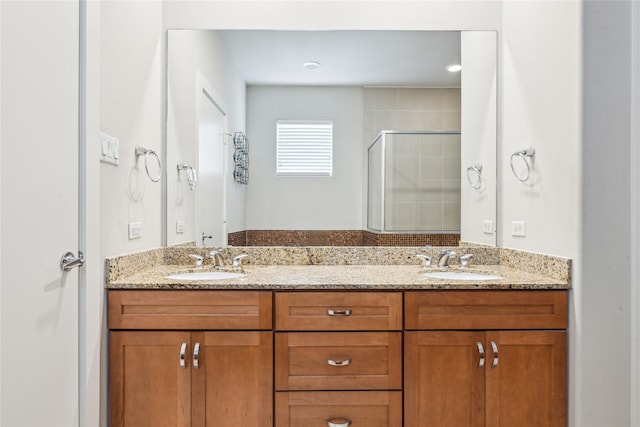 bathroom with a stall shower, a sink, and double vanity