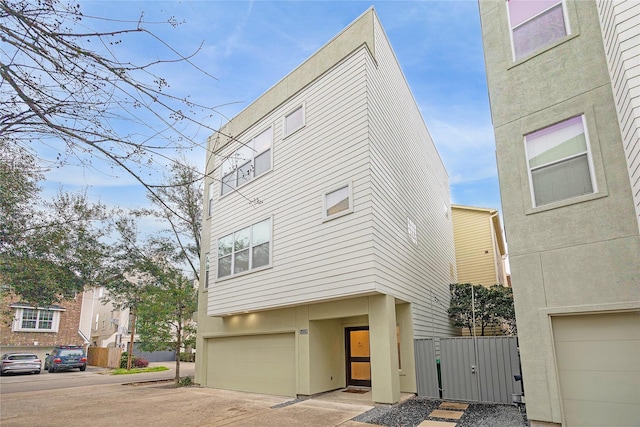 view of front facade with an attached garage, concrete driveway, and stucco siding