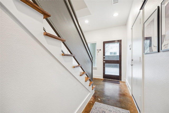 foyer with concrete flooring, recessed lighting, visible vents, baseboards, and stairs