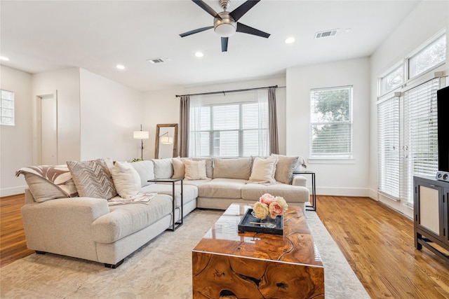 living room with a healthy amount of sunlight, light wood finished floors, visible vents, and recessed lighting