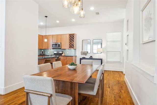 dining space with recessed lighting, light wood-type flooring, visible vents, and baseboards