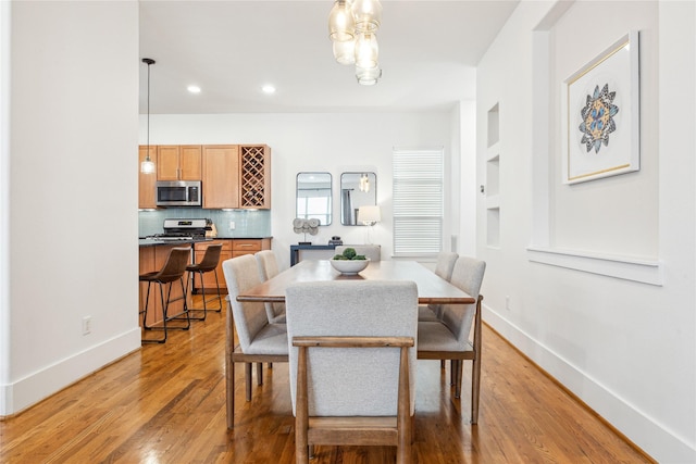 dining space with light wood finished floors, recessed lighting, built in features, and baseboards