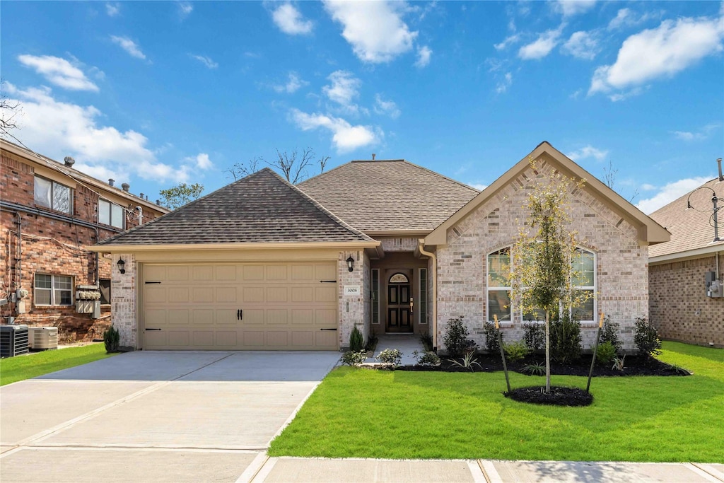 view of front of property with concrete driveway, a front lawn, roof with shingles, and brick siding