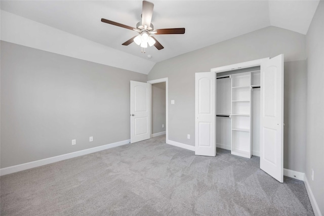 unfurnished bedroom featuring a ceiling fan, lofted ceiling, a closet, and baseboards