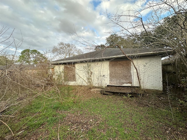 rear view of house with brick siding and fence