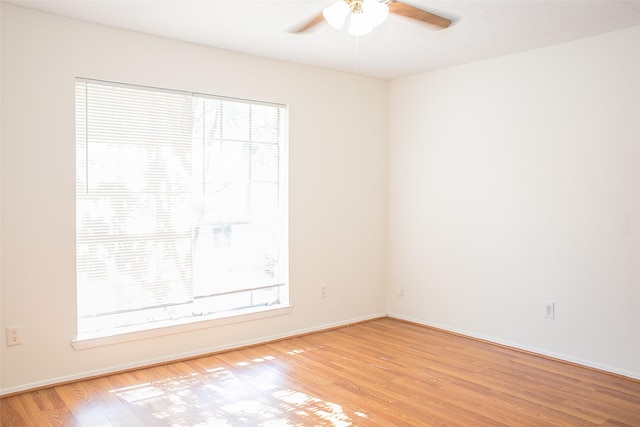 empty room featuring ceiling fan, light wood-type flooring, and baseboards