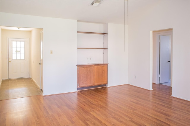 unfurnished room featuring light wood finished floors and visible vents