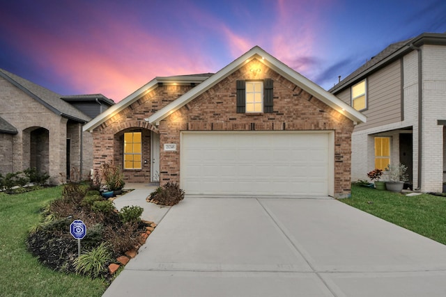 view of front of home with a garage, brick siding, driveway, and a front lawn