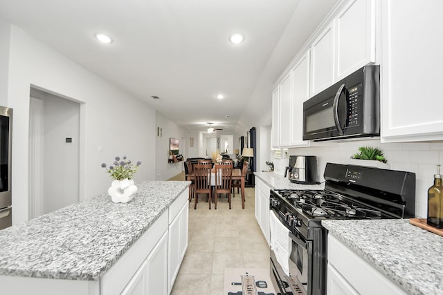 kitchen featuring recessed lighting, decorative backsplash, white cabinetry, a kitchen island, and black appliances