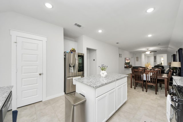 kitchen with open floor plan, stainless steel appliances, a center island, and white cabinets