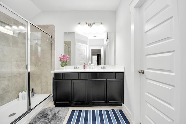 full bath featuring double vanity, a stall shower, and a sink