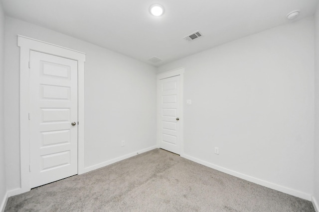 unfurnished room featuring light carpet, visible vents, and baseboards