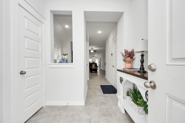 hall featuring recessed lighting, light tile patterned flooring, and baseboards