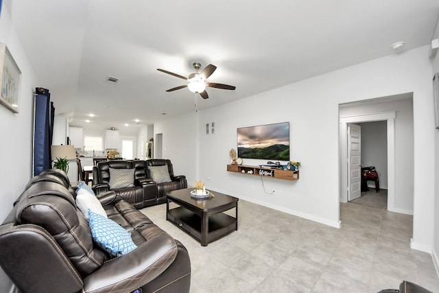 living area featuring baseboards, visible vents, and ceiling fan