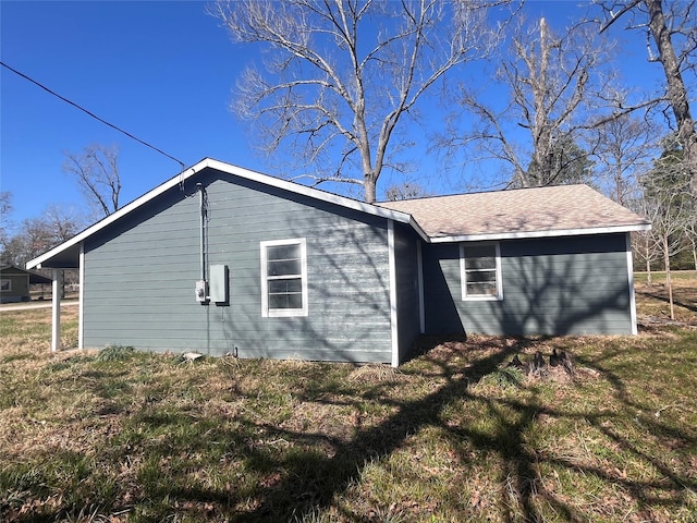 view of property exterior with a yard and a shingled roof