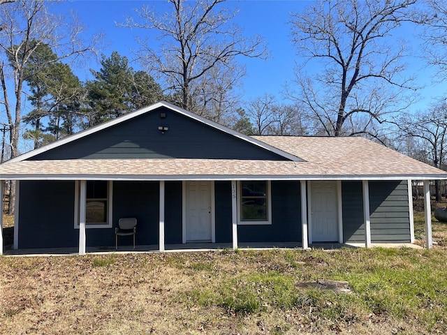 view of front facade featuring a shingled roof and a front yard