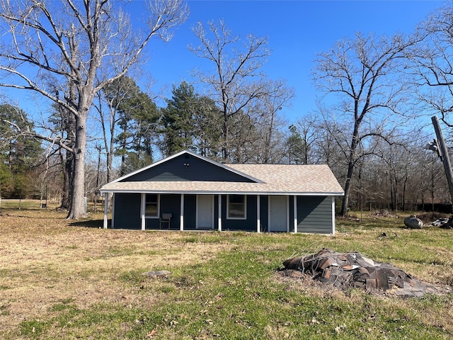 view of front of home with a front lawn and roof with shingles