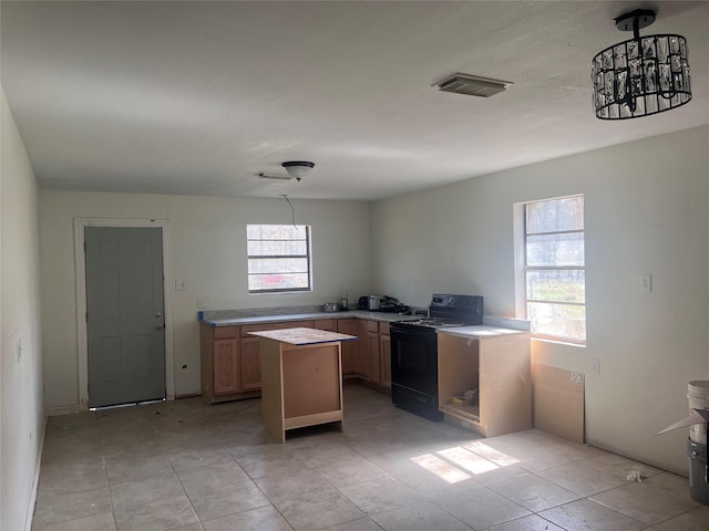 kitchen featuring visible vents, light countertops, black electric range oven, and a center island