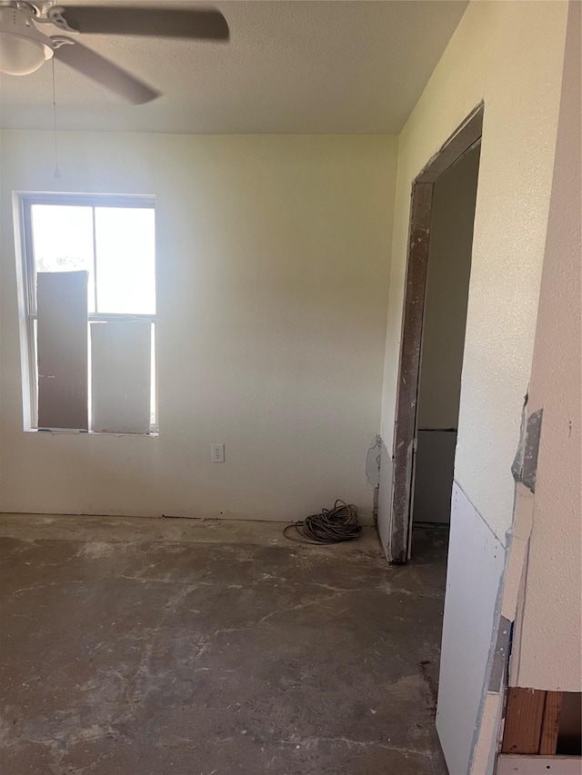 spare room with concrete flooring and ceiling fan