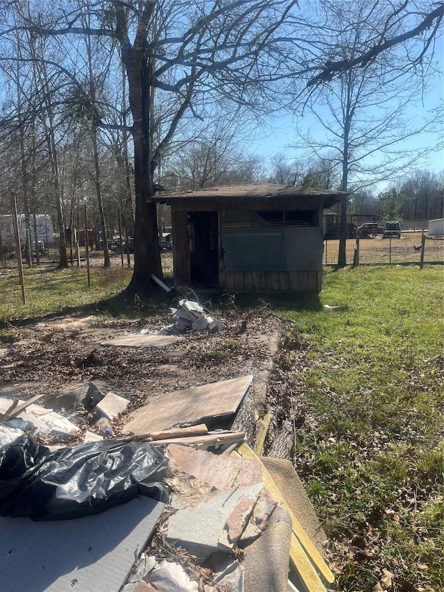 view of outbuilding featuring fence and an outdoor structure