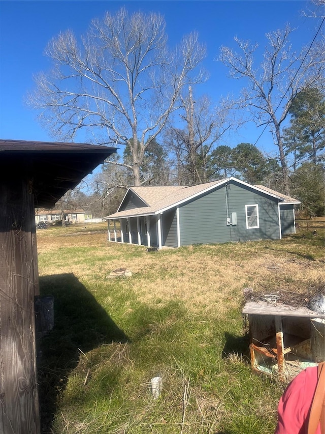 view of side of home with a yard