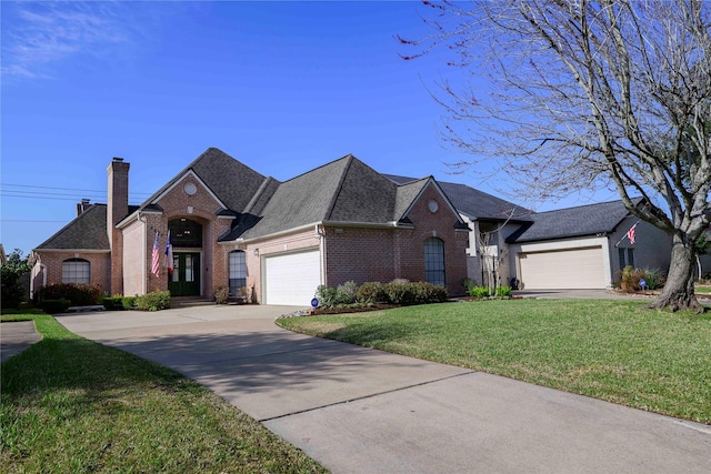 view of front of home featuring a front lawn, brick siding, a chimney, and an attached garage