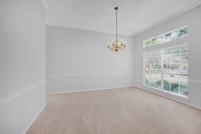 carpeted empty room with ornamental molding, baseboards, and an inviting chandelier