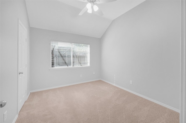 spare room with vaulted ceiling, ceiling fan, light carpet, and baseboards