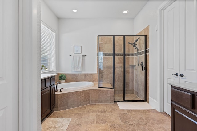 full bathroom with recessed lighting, vanity, a bath, stone finish flooring, and a stall shower