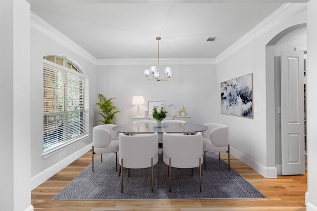 dining space with baseboards, visible vents, ornamental molding, and wood finished floors