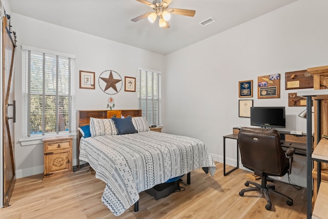 bedroom featuring visible vents, a ceiling fan, light wood-style flooring, and baseboards