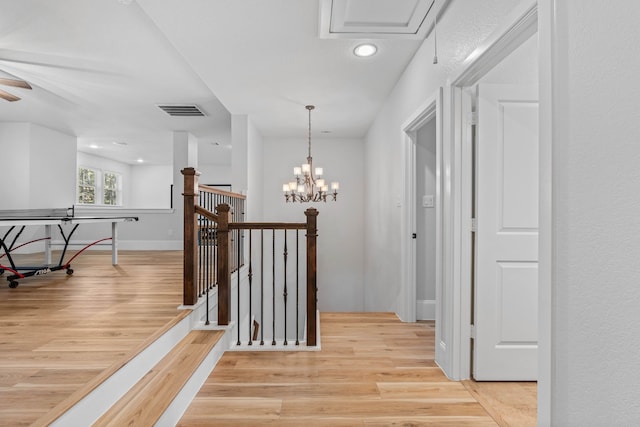 hall featuring a notable chandelier, recessed lighting, visible vents, an upstairs landing, and light wood-type flooring