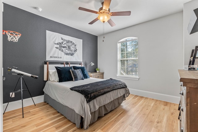 bedroom with light wood-type flooring, ceiling fan, and baseboards