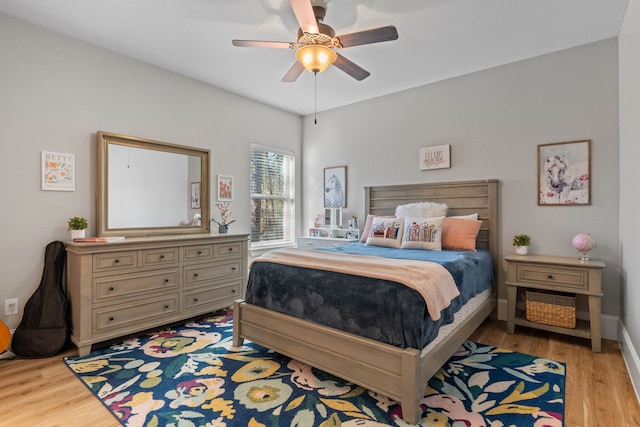 bedroom with light wood-style floors, baseboards, and a ceiling fan