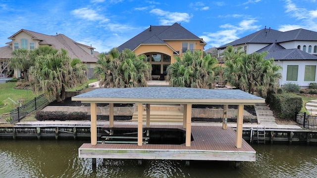 dock area with boat lift, a water view, fence, and a residential view