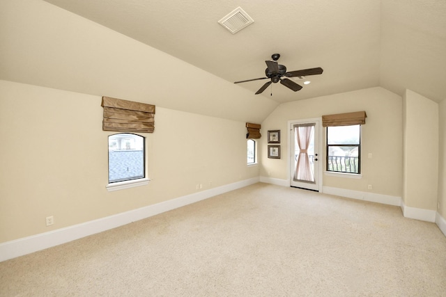 additional living space with baseboards, visible vents, a ceiling fan, light colored carpet, and lofted ceiling