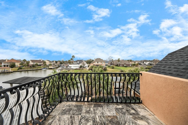 balcony with a residential view and a water view