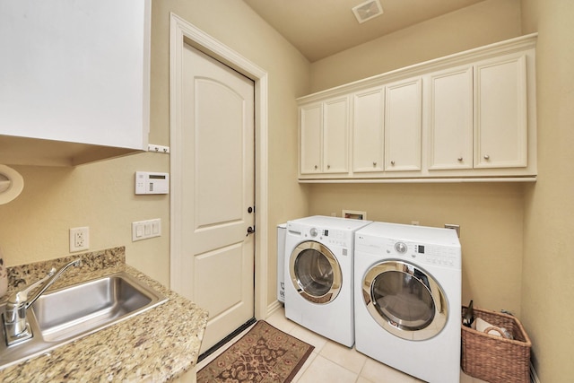 laundry area with light tile patterned floors, a sink, visible vents, independent washer and dryer, and cabinet space