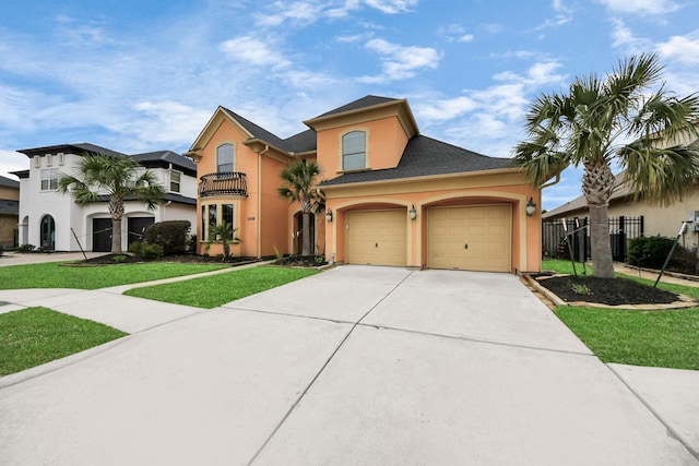 mediterranean / spanish-style house with a balcony, a front yard, concrete driveway, and stucco siding