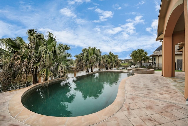 view of swimming pool featuring a pool with connected hot tub, a patio area, and fence