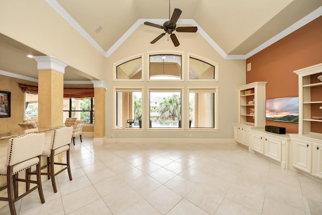 2256 Lake Cove Way, Seabrook, TX 77586 - unfurnished living room with light tile patterned floors, ceiling fan, baseboards, high vaulted ceiling, and ornate columns