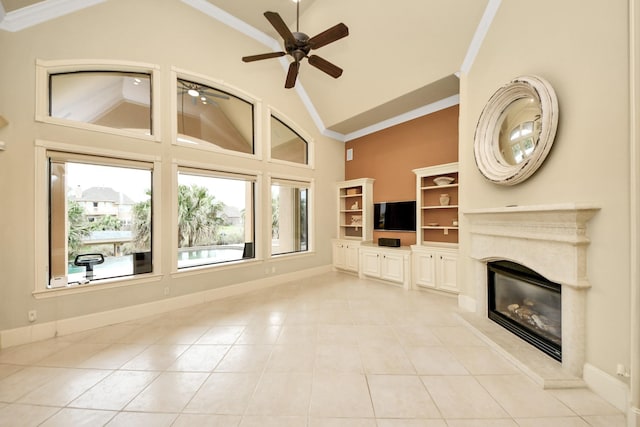 2256 Lake Cove Way, Seabrook, TX 77586 - unfurnished living room featuring a premium fireplace, ceiling fan, crown molding, light tile patterned floors, and high vaulted ceiling