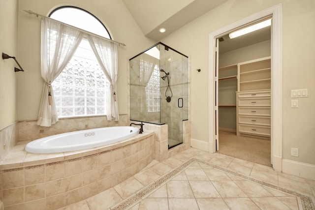 bathroom featuring a stall shower, baseboards, a walk in closet, and tile patterned floors