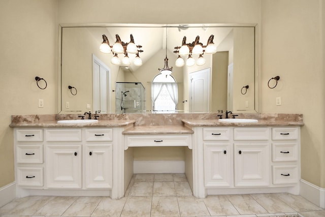 bathroom with double vanity, a stall shower, and a sink