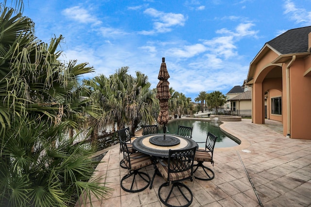 view of patio / terrace with an outdoor fire pit, a pool with connected hot tub, and fence